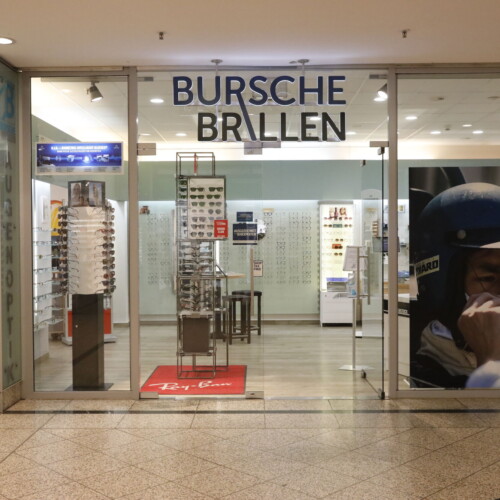 Blick auf Eingangsbereich bei Bursche Brillen im Forum Köpenick, mit Logo über dem Eingang.