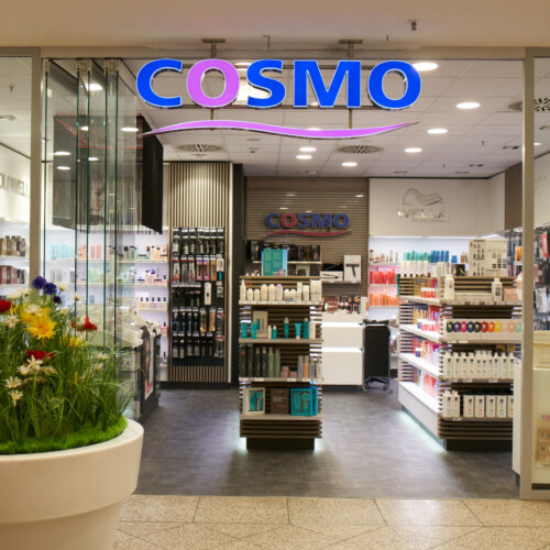 Eingangsbereich von Cosmo im Forum Köpenick, mit Logo über dem Eingang.