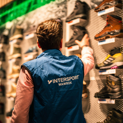 Intersport-Mitarbeiter und Ausstellungswand mit Outdoor-Schuhen bei Intersport im Forum Köpenick.